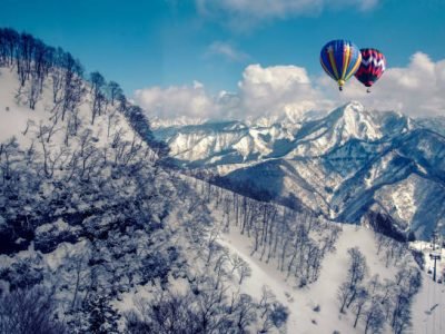 Colorful hot-air balloon flying over snowcapped mountain